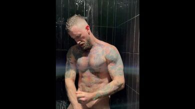 uomo muscoloso tatuato Troy Daniels che si masturba sotto la doccia